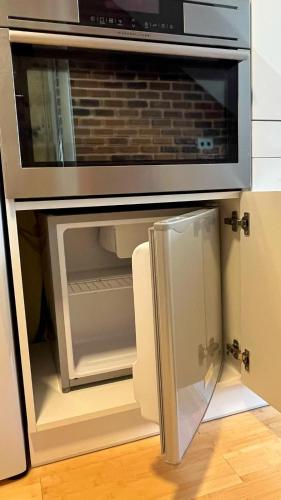 an open microwave oven with a glass door at Věžička u Vřídla (Tower apartment in centre) in Karlovy Vary