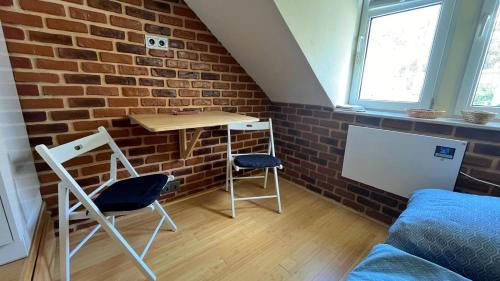 a room with a brick wall and a table and chairs at Věžička u Vřídla (Tower apartment in centre) in Karlovy Vary