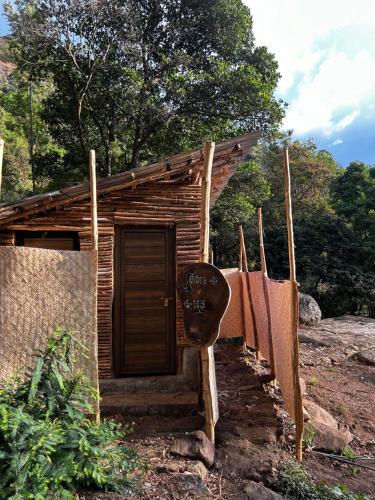 a small wooden house with a sign in front of it at Woodman Hideout in Kanthalloor