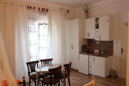 a kitchen and dining room with a table and chairs at Pansion Ana in Podaca
