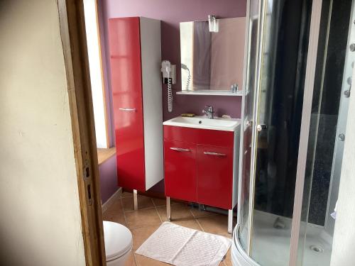 y baño con lavabo rojo y ducha. en Auberge des 7 ecluses, en Rogny