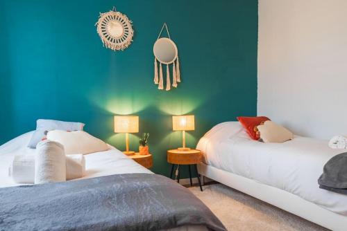 2 camas en una habitación con paredes y lámparas azules en Nouveau - La Bulle Lumineuse - Terrasse, en Brumath