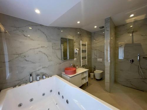 een grote badkamer met een bad en een douche bij Reign Hotel in Vorë