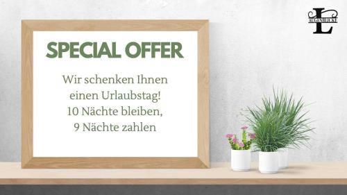 a sign for a special offer with two plants on a shelf at Landhaus Augenblicke Olsberg in Olsberg