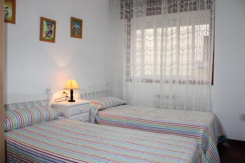 2 aparte bedden in een slaapkamer met een raam bij Apto Peteiro in Ponteareas