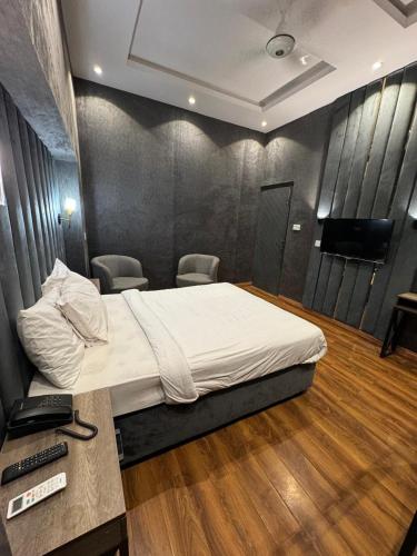 a bedroom with a bed and a desk and a television at Shelton Boulevard Islamabad in Islamabad