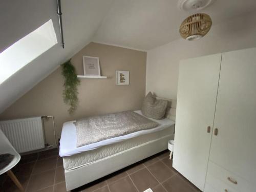a small bedroom with a bed and a staircase at kleines Einzelzimmer Nr. 5 in Kleve in Kleve