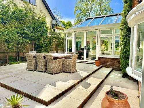 d'une terrasse avec une table et des chaises. dans l'établissement Golf Course View - Large Four Bed Home with Garden and Parking - New Forest and Beach Links, à Ferndown