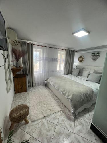 a bedroom with a large bed and a chair at Himalayas in Gjirokastër