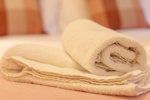 a white towel sitting on top of a bed at Cozy Coach House Nr Golf & Beach in Broadstairs