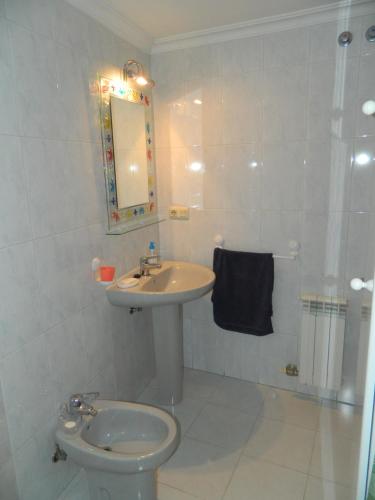 een witte badkamer met een wastafel en een toilet bij Apto Peteiro in Ponteareas