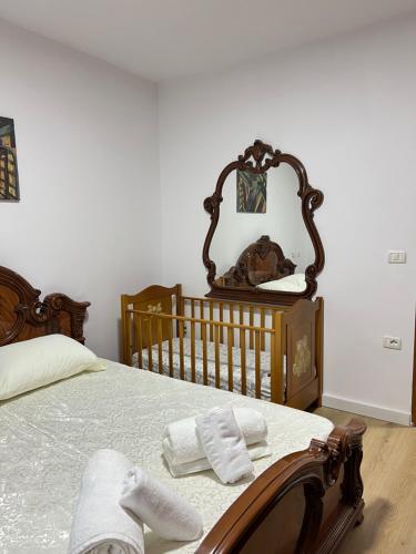 ein Schlafzimmer mit einem Kinderbett und zwei Handtüchern auf einem Bett in der Unterkunft Glauk Apartment in Berat