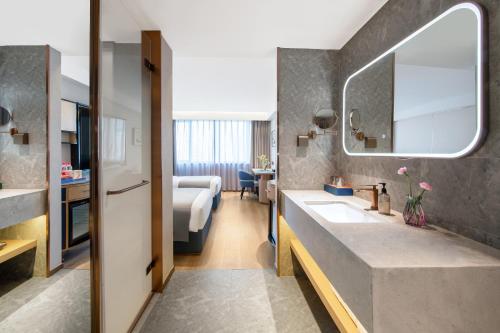 杭州市にあるLan'ou International Hotel - Wulin Square West Lakeのバスルーム(シンク付)、ベッド1台が備わります。