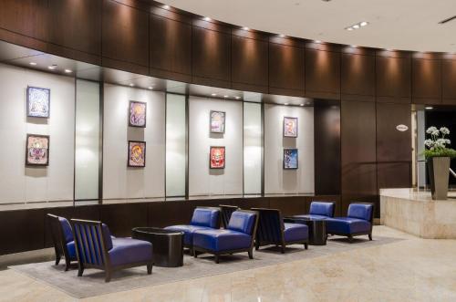 a waiting room with blue chairs and pictures on the wall at InterContinental Toronto Centre by IHG in Toronto