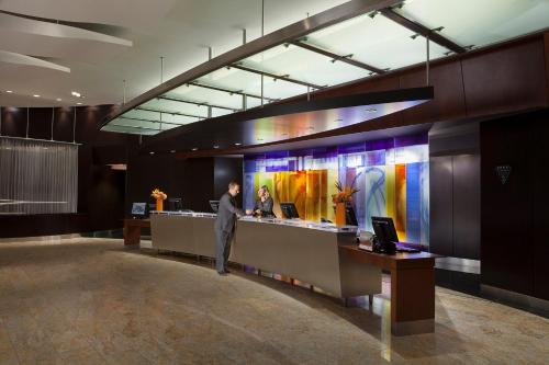 a man standing at a counter in a lobby at InterContinental Toronto Centre by IHG in Toronto