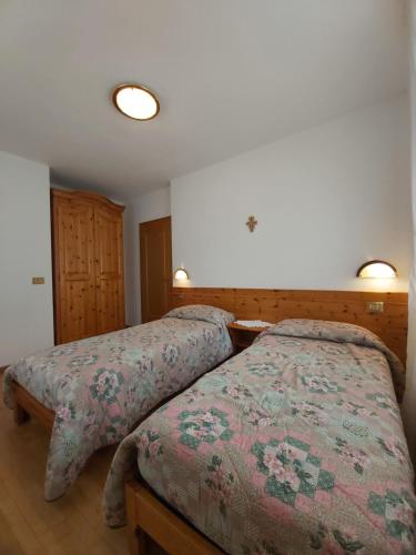 dos camas sentadas una al lado de la otra en un dormitorio en Majon Di Roces, en Canazei