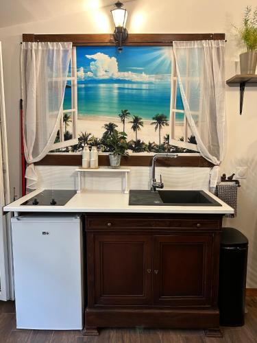 une cuisine avec une fenêtre donnant sur la plage dans l'établissement La Casa d'Ailleurs BERRY SEJOURS, à Châteauroux