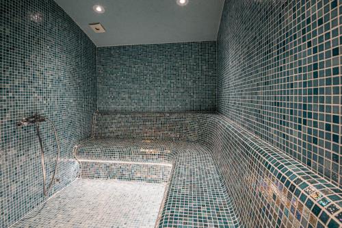 a bathroom with a shower with tiled walls at Hotel Samara with Relax area in Balchik