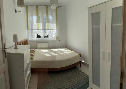 a small bedroom with a bed and a window at Marina in Jarosławiec
