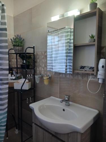 uma casa de banho com um lavatório e um espelho em Joannas Luxury Apartment em Corfu Town