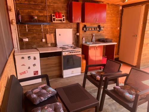 a kitchen with a stove and some chairs in it at Ada Bojana kucica na vodi in Ulcinj