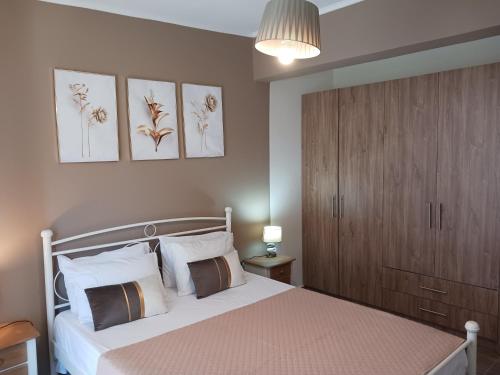 um quarto com uma cama branca e um armário de madeira em Joannas Luxury Apartment em Corfu Town