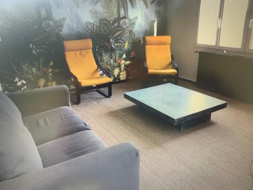 un salon avec deux chaises et une table basse dans l'établissement Les ursulines, à Lannion