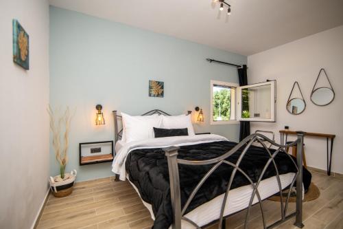 a bedroom with a bed with a metal frame at Armoniahousesuites in Perítheia