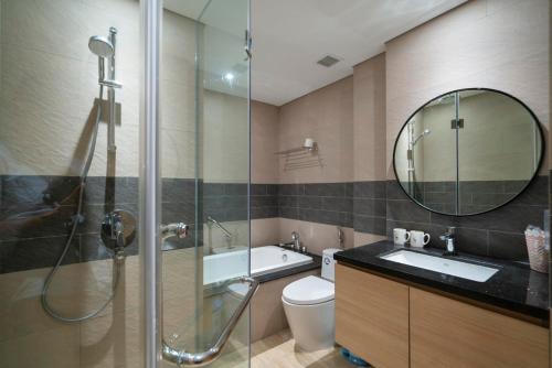 y baño con ducha, lavabo y espejo. en Khách sạn cao cấp citadines marina HẠ LONG, en Ha Long