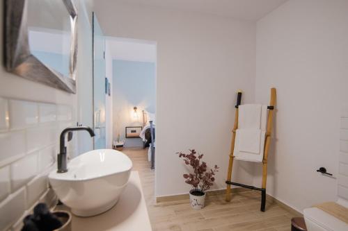 a bathroom with a white sink and a mirror at Armoniahousesuites in Perítheia