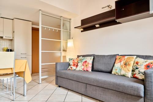 Il comprend un salon avec un canapé gris et une cuisine. dans l'établissement Appartamento Dilva, à Vigolo Vattaro