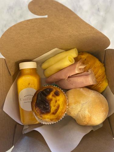een doos met eten, met daarin een sandwich en een fles mosterd bij Coruja’s House AL OPO in Porto