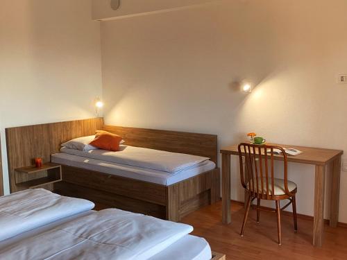 a bedroom with two beds and a desk and a chair at Apartma Domačija Bole in Sežana