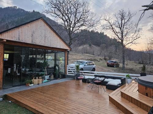 a house with a wooden deck with a car parked at White Story in Brezoi