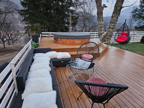 a deck with two chairs and a barrel on it at White Story in Brezoi