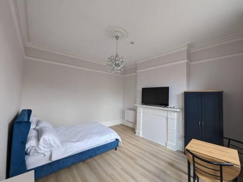 a bedroom with a bed and a tv and a table at Studio flat in York in York