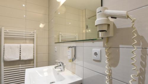 a bathroom with a sink and a hair dryer at HOTEL Am Spichernplatz in Düsseldorf
