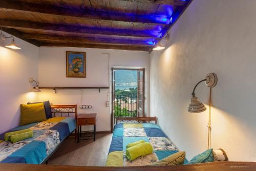 1 dormitorio con 2 camas, mesa y ventana en II Sogno di Anna & Emma, en Ossuccio