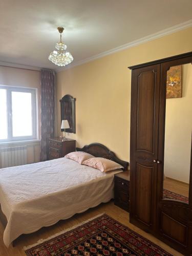 a bedroom with a bed and a dresser and a window at Rudaki room in Dushanbe