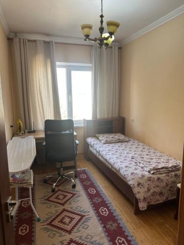 a bedroom with a bed and a desk and a chair at Rudaki room in Dushanbe