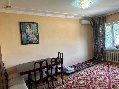 a living room with a table and a couch at Rudaki room in Dushanbe