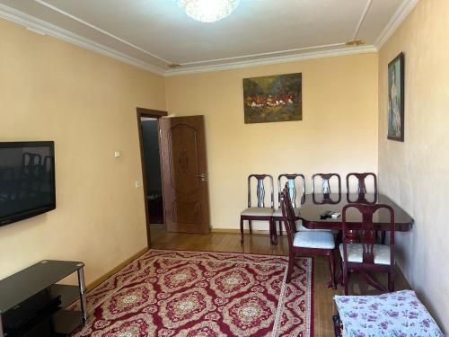 a living room with three chairs and a table at Rudaki room in Dushanbe