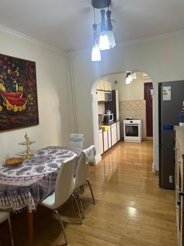 a dining room with a table and chairs and a kitchen at Rudaki room in Dushanbe