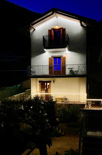 a white building with a blue window and a balcony at II Sogno di Anna & Emma in Ossuccio