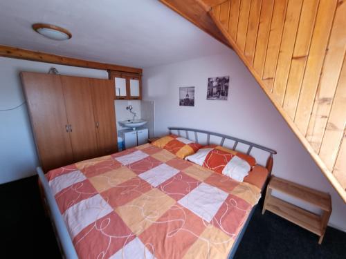 a bedroom with a bed and a staircase at Penzion Tomy Pihlov in Horní Planá
