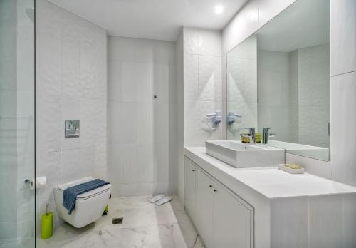bagno con servizi igienici, lavandino e specchio di Lotus Center ad Atene