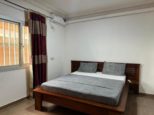 1 dormitorio con cama y ventana en Appart meublé haut standing, WIFI, TV - Yaoundé, Omnisports en Yaundé