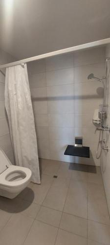 a white bathroom with a toilet and a shower at Auberge de Bellelay Restaurant Chez Aron Balde in Bellelay