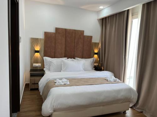 a hotel room with a large bed with white sheets at Hotel Rais in El Marsa