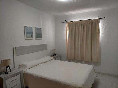 Habitación blanca con cama y ventana en Apartamento céntrico en primera linea de playa, en Peñíscola